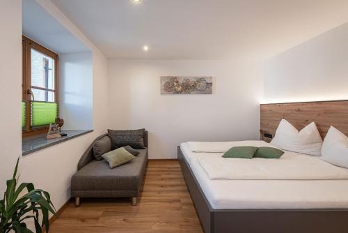 a bedroom with a bed and a chair at Wohnung Morgenduft Schnalserhof in Laces