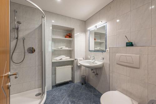 a bathroom with a shower toilet and a sink at Wohnung Morgenduft Schnalserhof in Laces