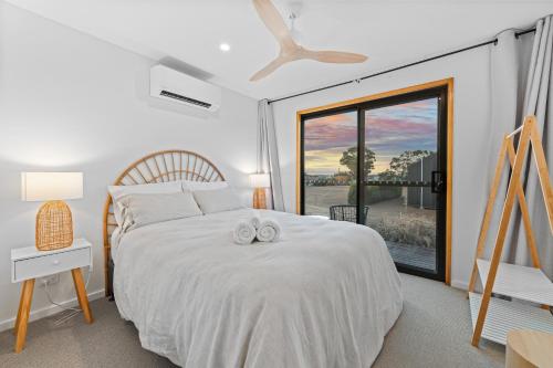a bedroom with a large white bed with a window at Three Ponds Estate in Temora