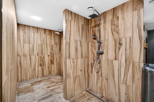 a bathroom with a shower with a wooden wall at Resort Rybníček in Blatnice