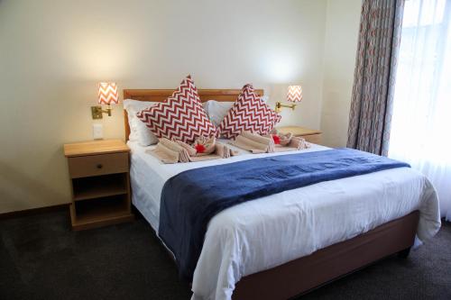 a bedroom with a large bed with pillows on it at Gooderson Leisure Riverbend Chalets Self Catering in Drakensberg Garden