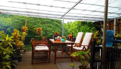 a patio with a table and chairs under a pergola at Spacious studio 4, AC, kitchenette, central location in Coron