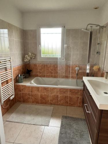 a bathroom with a tub and a sink at Maison proche Hossegor in Tosse