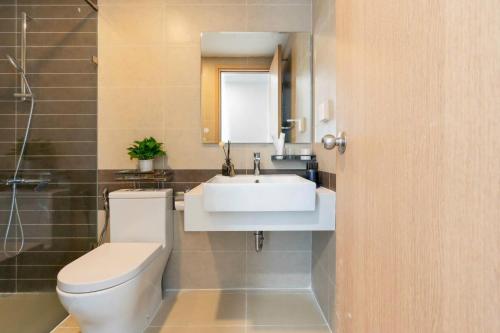 a bathroom with a sink and a toilet and a mirror at Apartment Luxury Center HCM City with Infinity Pool in Ho Chi Minh City