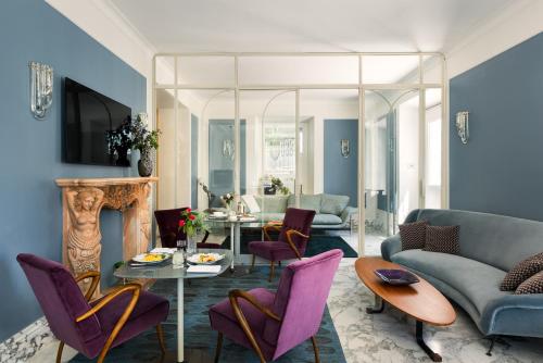 a living room with purple chairs and a fireplace at Nus Hotel Poerio in Rome