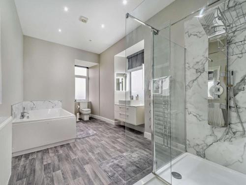 a bathroom with a shower and a tub and a sink at 3 Bed in Girvan oc-96394 in Girvan