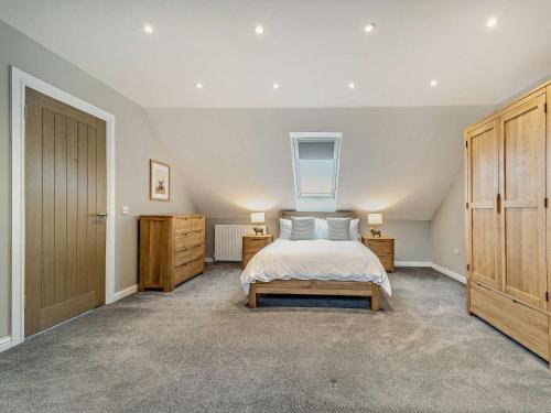 a large bedroom with a bed and wooden cabinets at 3 Bed in Girvan oc-96394 in Girvan
