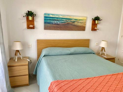 a bedroom with a bed with two lamps and two pictures on the wall at Luxury Doña Carlota in Torremolinos