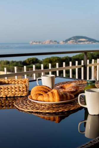 a table with a plate of bread and cups of coffee at La Vista Formia B&B in Formia