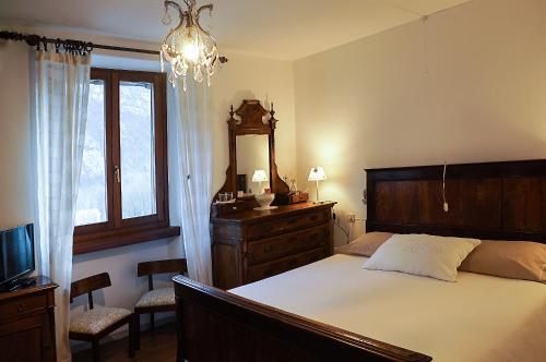 a bedroom with a bed and a dresser and a window at Bed & Breakfast Casa Marinella in Lenna