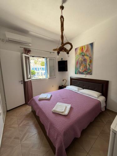a bedroom with a purple bed with two towels on it at Aegean Dream Room in Kamares