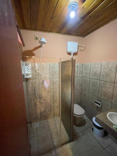 a bathroom with a shower with a toilet and a sink at Aconchego do céu in Conceição da Ibitipoca