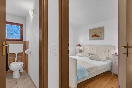 a white bedroom with a bed and a toilet at Authentic Hideaway by Riva with Free Parking in Podgora