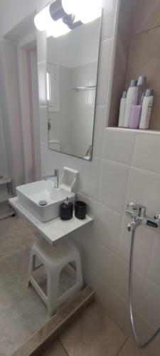 a white bathroom with a sink and a mirror at Aegean Dream Room in Kamares
