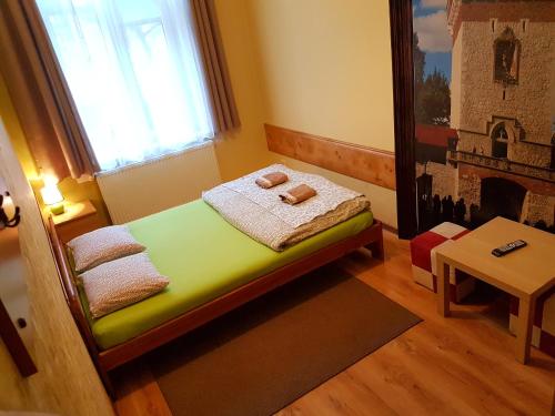 um pequeno quarto com uma cama num quarto com uma janela em Dream Hostel & Apartments em Cracóvia