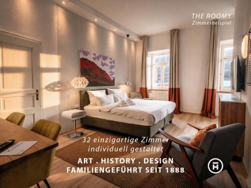 a bedroom with a bed and a table and a desk at The Townhouse Ruhpolding - Individual Design & Casual Concept - Chiemgau Karte in Ruhpolding