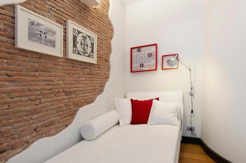 a room with a brick wall and a white couch at C123 Luxury in Chiavari