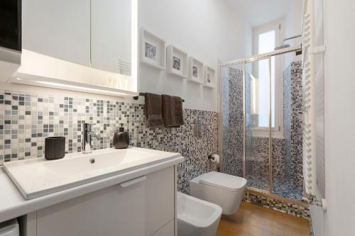 a white bathroom with a sink and a toilet at C123 Luxury in Chiavari