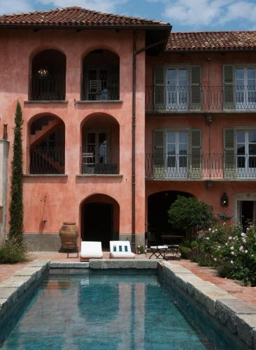 a house with a swimming pool in front of a building at Relais Conac 1888 - Luxury B&B - Adults Only in Castelnuovo Don Bosco