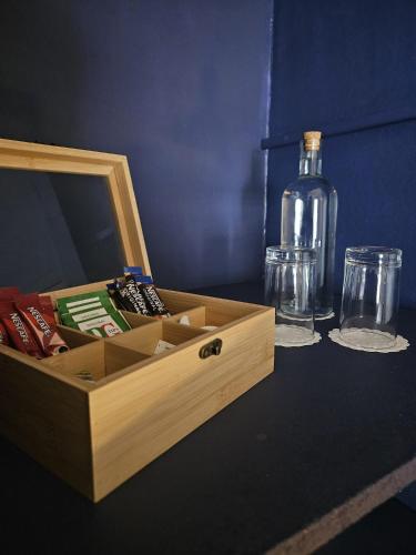 a wooden box with a bottle and glasses on a table at The Inn at Strathyre in Strathyre