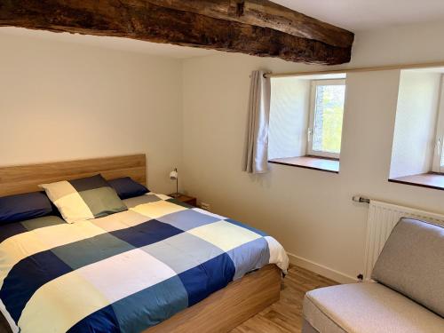 a bedroom with a bed and two windows at AppartCosy 27 Epine in Châteaubourg