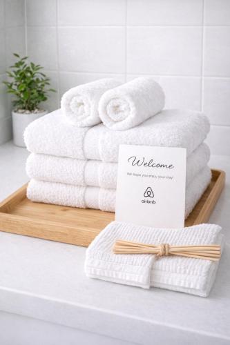 a stack of towels on a wooden tray in a bathroom at Comfy & Cozy in Seoul