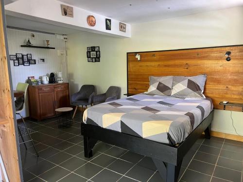 a bedroom with a bed with a wooden headboard at Coconut Studio in Capesterre-Belle-Eau