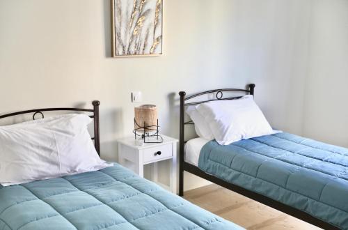 two beds sitting next to each other in a bedroom at Adriana's Summer House in Kassiopi