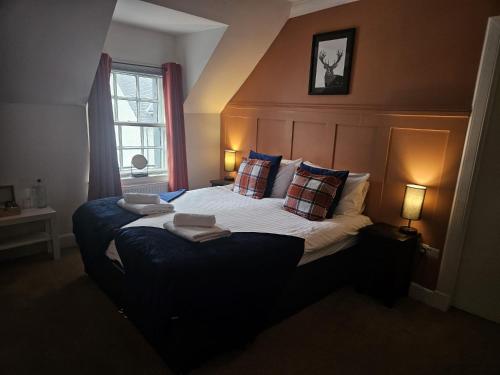 a bedroom with a large bed with pillows and a window at The Inn at Strathyre in Strathyre