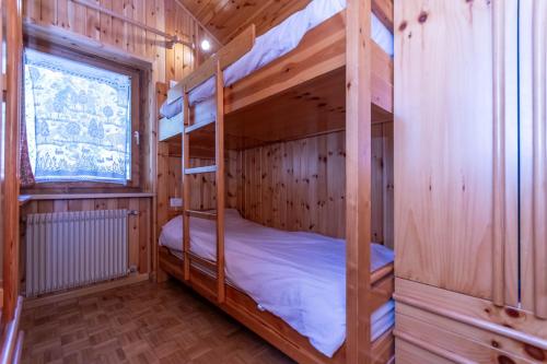 a bedroom with two bunk beds in a wooden cabin at Ciasa Gaia in Mazzin
