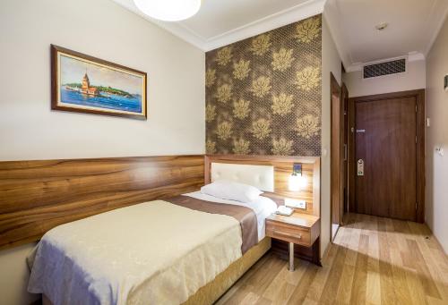 イスタンブールにあるマイ ローズ ホテルのベッドと木製の壁が備わるホテルルームです。