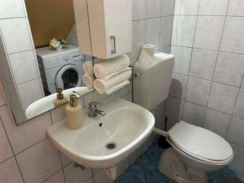 a bathroom with a toilet and a sink and a washing machine at Apartment Bačvice in Split