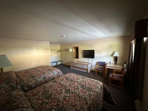 a hotel room with two beds and a desk at Budget Inn - Cambridge in Fairdale