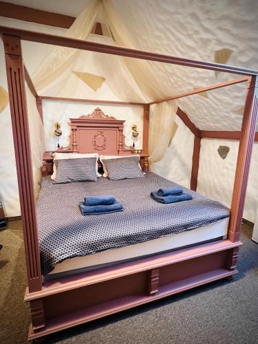 a bedroom with a canopy bed with blue towels on it at Kurna Mõis in Kurna