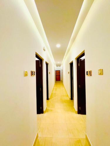a hallway with doors and a long hallway with tile floors at FabHotel Elvin's Place in Calangute