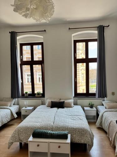 a bedroom with a large bed and two windows at Apartament przy Kościele in Świdnica
