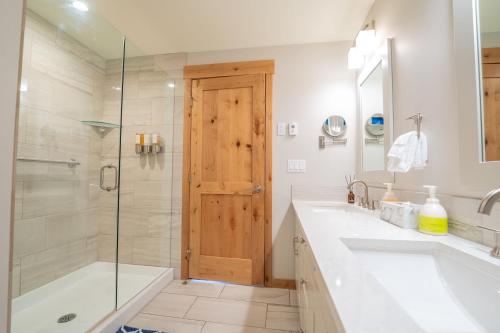 a bathroom with a shower and a tub and a sink at White Spruce Condo by Canadian Rockies Vacation Rentals in Canmore
