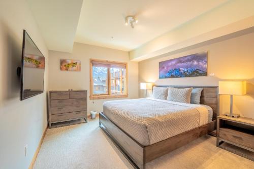 a bedroom with a bed and a window at White Spruce Condo by Canadian Rockies Vacation Rentals in Canmore