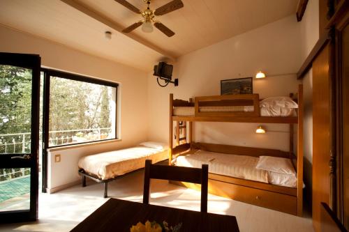 ブレンゾーネにあるVillaggio Albergo Casa e Lagoのベッドルーム1室(二段ベッド2組付)、バルコニーが備わります。