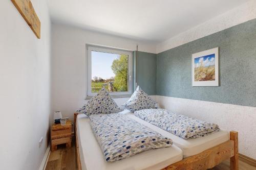 a bedroom with two beds and a window at Ferienwohnung glüxnest in Bernstadt