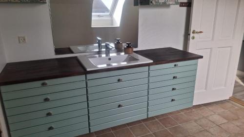 a bathroom vanity with a sink and a mirror at Søndergaarden in Øster Ulslev