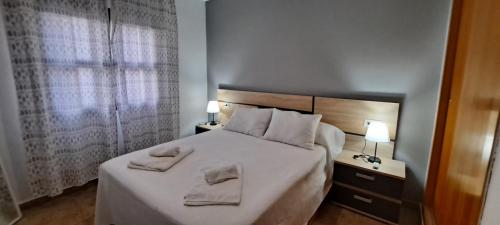 a bedroom with a bed with two towels on it at Enebrales 304 in Punta Umbría