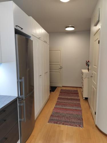a kitchen with white cabinets and a rug at Varakoti Helmi in Loimaa