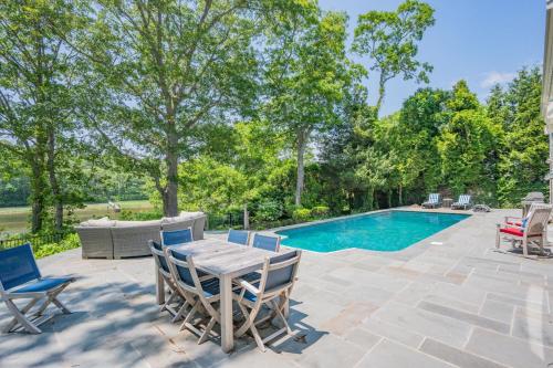 a patio with a table and chairs next to a swimming pool at Bay Breeze Escape—Pool, Game Room Views in Centerville