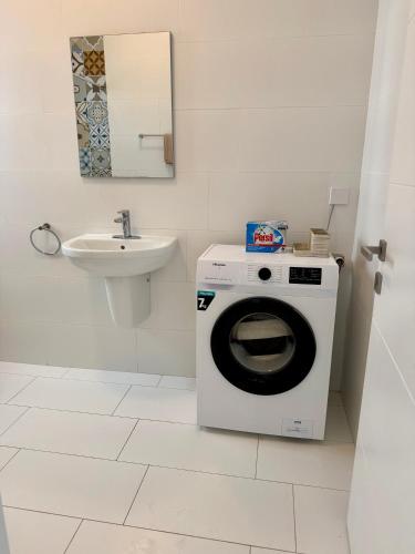a bathroom with a washing machine and a sink at Azure Dome Residences in Għajnsielem