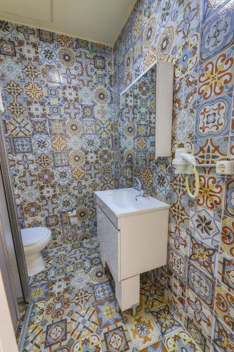 a bathroom with a sink and a toilet and tiles at Angela Inn Boutique in Istanbul