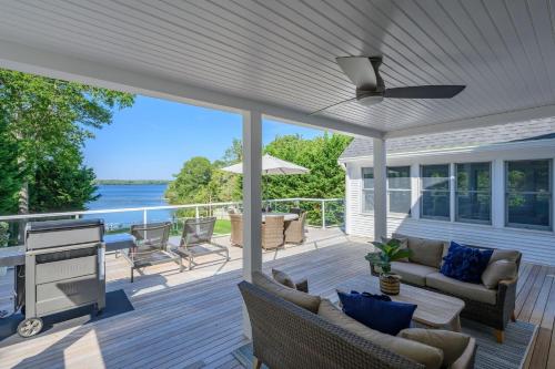 a screened in porch with a ceiling fan at Relax by the Lake: Private Beach Views in Centerville