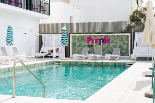 a hotel swimming pool with chairs and a bed at The Purple Hotel - Adults Only in San Antonio