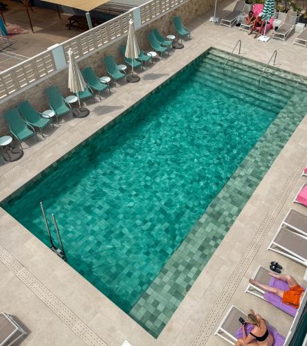 an overhead view of a large swimming pool with green chairs at The Purple Hotel - Adults Only in San Antonio