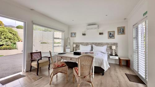 a bedroom with a bed and a table and chairs at Somerset View Guest House in Somerset West
